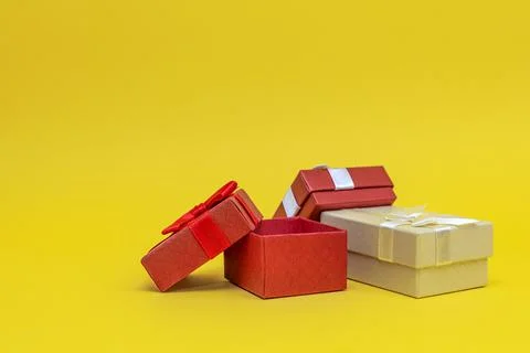 Gift boxes on a yellow background. Red gift boxes, open box. Postcard for pri Stock Photos