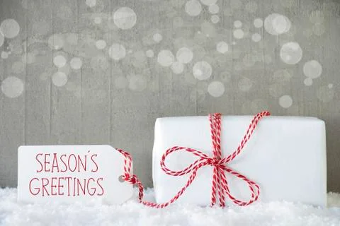 Gift, Cement Background With Bokeh, Text Seasons Greetings Stock Photos