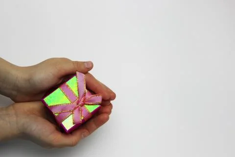 A gift in children's hands, on a white background, a girl gives gifts Stock Photos