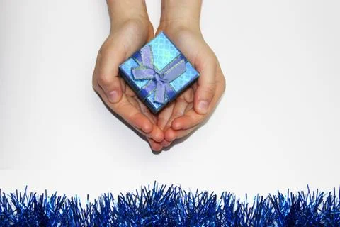A gift in children's hands, on a white background, a girl gives gifts Stock Photos