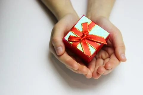 A gift in children's hands, on a white background, a girl gives gifts Stock Photos