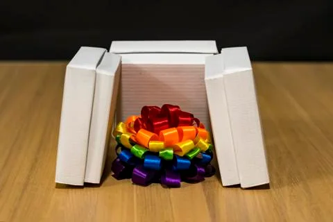 Gift composition. Box with stripes of different colors. Multi-colored bow. There Stockfoto's