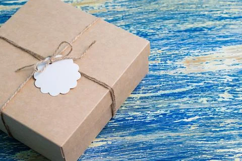 Gift in craft box on blue background, copy space and mockup Fotos Stock