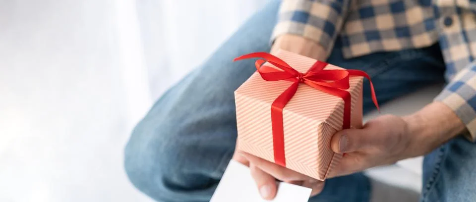 Gift in craft packaging and tools in the hands of Father's Day, give, a gif.. Stock Photos