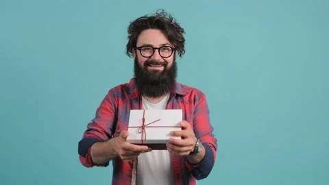 Gift delivery. Close up of a smiling man offering wrapped box to camera. Stock Footage 142097508