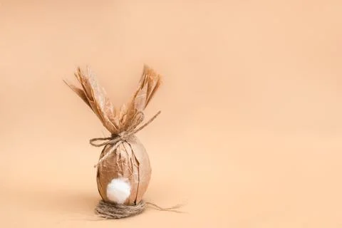 Gift Easter egg in craft brown paper in the shape of a rabbit with copy space Stock Photos