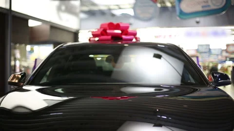 Gift expensive black car with red symbolic ribbon on a roof Stock Footage 49998560