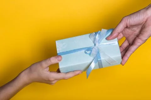 Gift is given to the recipient on a yellow background Stock Photos
