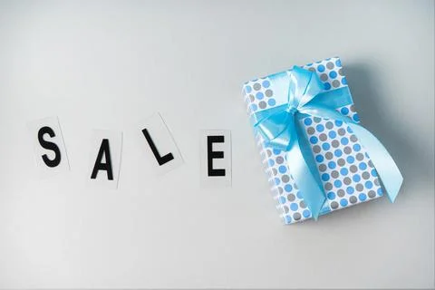 Gift on a gray background in a blue package. Black Friday concept for Boxing Stock Photos
