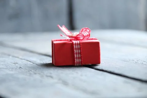 Gift idea, a box with a ribbon lies on a vintage table Stock Photos