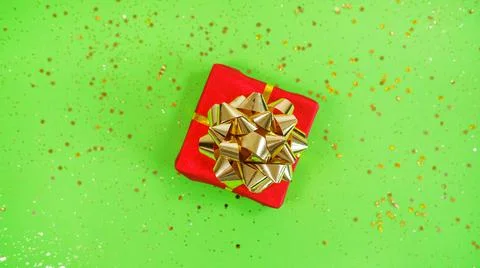 Gift or present box and confetti on green Festive backdrop Stock Photos