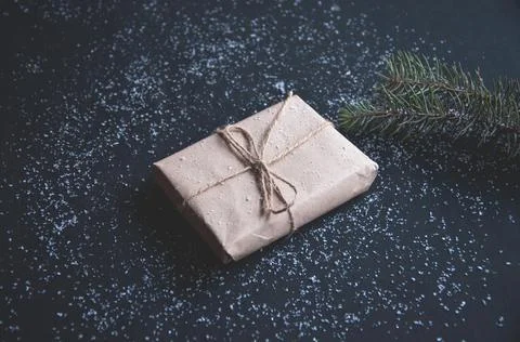 Gift or present box and snow on a black table. Stock Photos