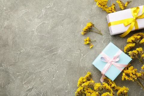 Gift or present box and flower on yellow background. Pastel color. Greeting c Stock Photos