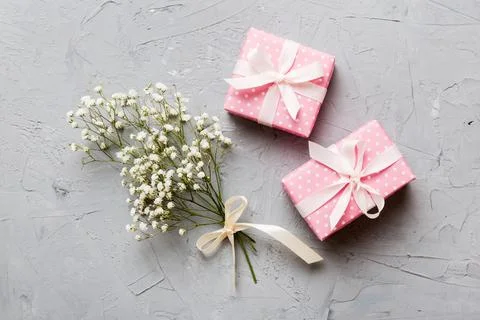 Gift or present box and flower gypsophila on light table top view. Greeting.. Stock Photos