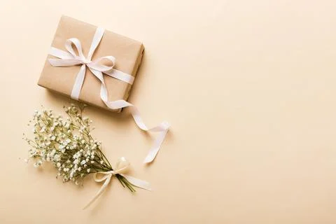 Gift or present box and flower gypsophila on light table top view. Greeting c Stock Photos