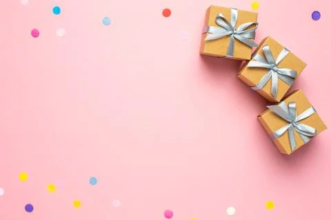 Gift or present box and color confetti on pink table with space for text. C.. Stock Photos