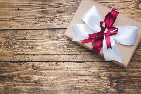 Gift or present box with a big bow on a wooden table top view. Flatlay comp.. 스톡 사진
