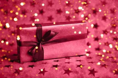 Gift or present box decorated with bow on red background. Top view, copy space Foto stock