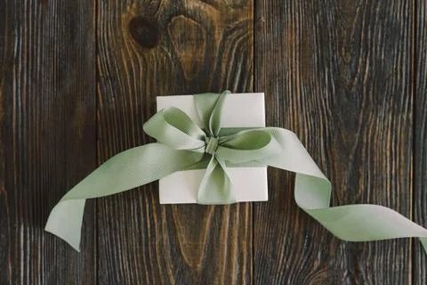 Gift or present box with green ribbon on wood background 스톡 사진