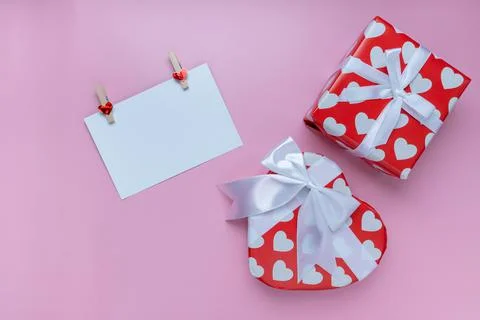 Gift or present box, mini heart and white greeting card on pink background. f Stock Photos