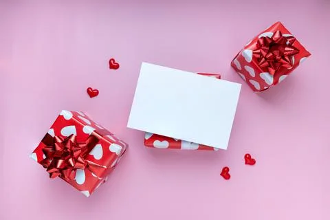 Gift or present box, mini heart and white greeting card on pink background. f Stock Photos