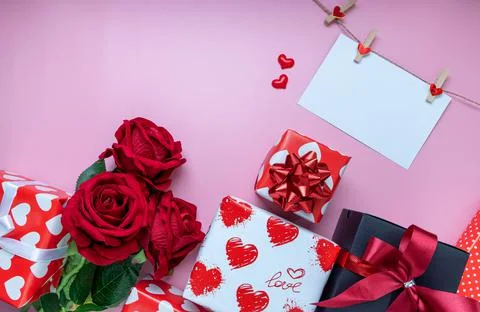 Gift or present box, red rose, mini heart and white greeting card on pink bac Stock Photos