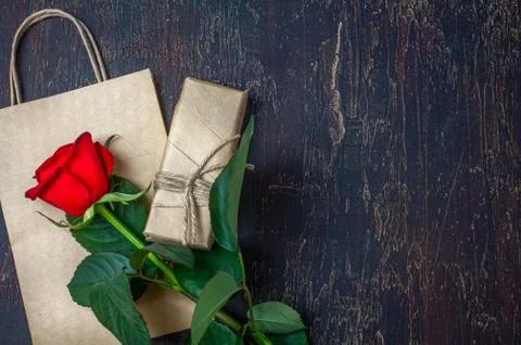 Gift or present box wrapped in kraft paper and rose Flat lay styling. Copy space Stock Photos
