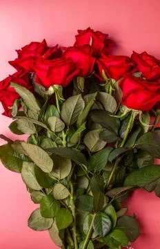 Gift or present box wrapped in kraft paper and roses on blue background. Flat Stock Photos