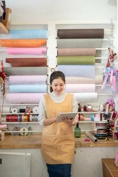 Gift packaging retail worker checking inventory on a tablet in a colorful w.. Foto stock
