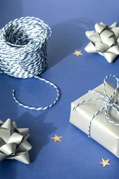 Gift packaging: silver bows for gift decoration, blue gift rope, gift in a si Stock Photos