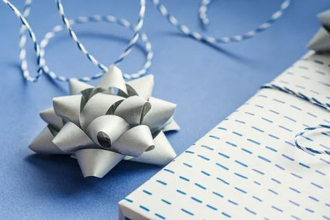 Gift packaging: silver bows for gift decoration, blue gift rope, gift in a wh Stock Photos
