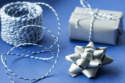 Gift packaging: silver bows for gift decoration, blue gift rope, gift in a si Stock Photos