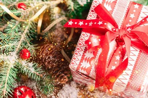 Gift present in festive paper packaging with red ribbon bow close-up Stock Photos