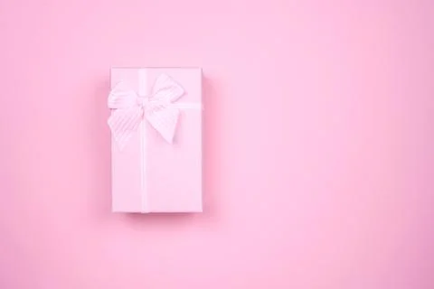 Gift rectangular pink box with bow on a pure pink background Stockfoto's