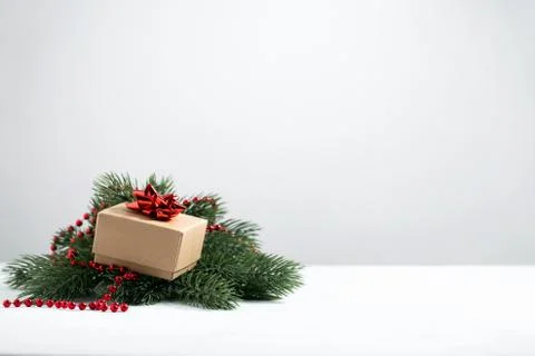 Gift with a red bow in the green pine tree branches Stock Photos