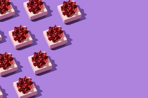 Gift with a red bow pattern on the purple background Stock Photos