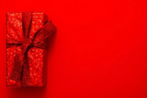 Gift in a red package on a red background. Christmas, Valentine's Day gift. Stock Photos