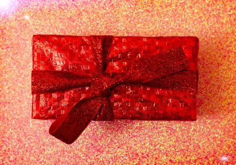Gift in a red package on a red background. Christmas, Valentine's Day gift. Stock Photos