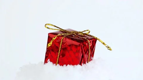 Gift in red packaging on the snow, gift rotation. Selective focus. Stock Footage 221061894