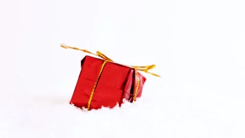 Gift in red packaging on the snow, gift rotation. Selective focus. Stock Footage 222390045