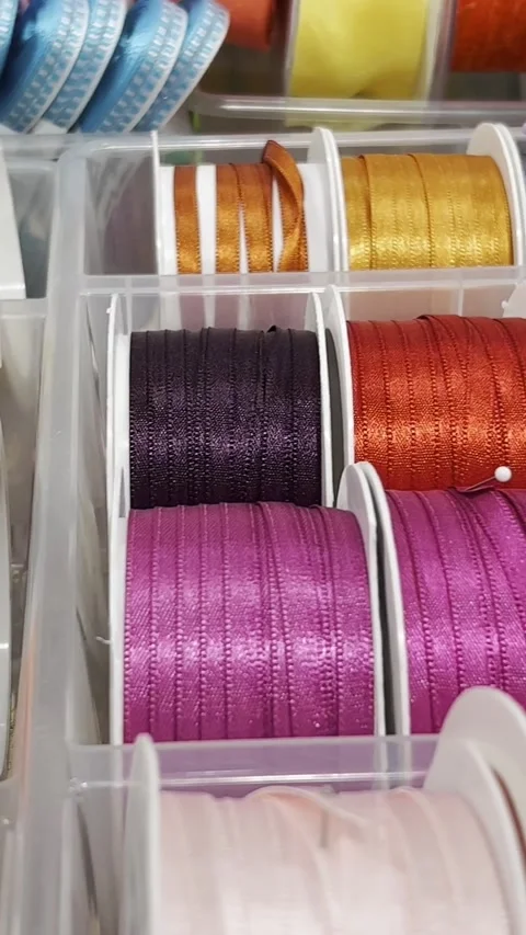 Gift ribbons of different colors in a textile store. Slow motion. Vertical video Vídeo Stock 250385867