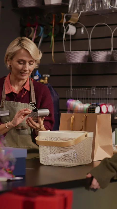 Gift Shop Worker Accepting Payment of Client Using Smartphone Stock Footage 321340708