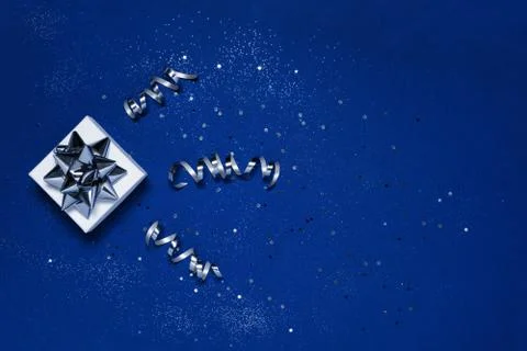 Gift with silver decorations on blue background Stock Photos