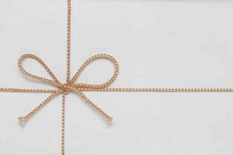 Gift String Bow Small Golden String Bow at White Gift Wrap Copyright: xZoo... Stock Photos