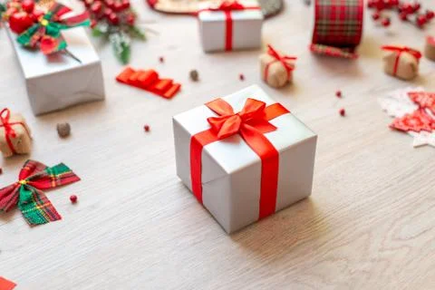 Gift on table surrounded by decorations and gifts. Concept of Christmas prepa Stock Photos