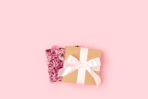Gift with a tied bow. Open box with flowers inside. Stock Photos