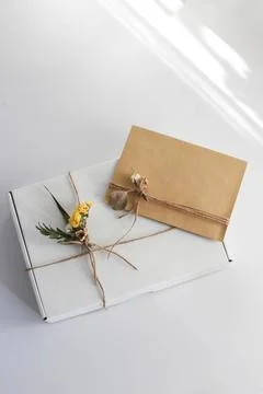 Gift wrap with envelope in white and beige colors Stock Photos