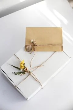 Gift wrap with envelope in white and beige colors Stock Photos