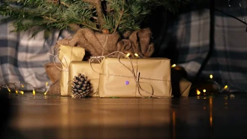 Gift wrapped in brown paper and string with Christmas lights bokeh background Stock Footage 313453185
