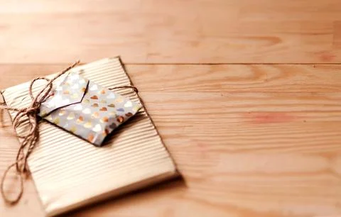 Gift-wrapped package with decorative envelope tied with twine, resting on a Stock Photos